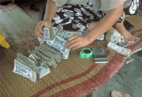 Un commerçant compte de l'argent à Mong Cai - baie d'halong