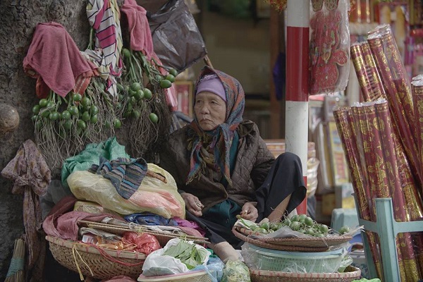 Une vieille marchande sur le trottoir à Hanoi